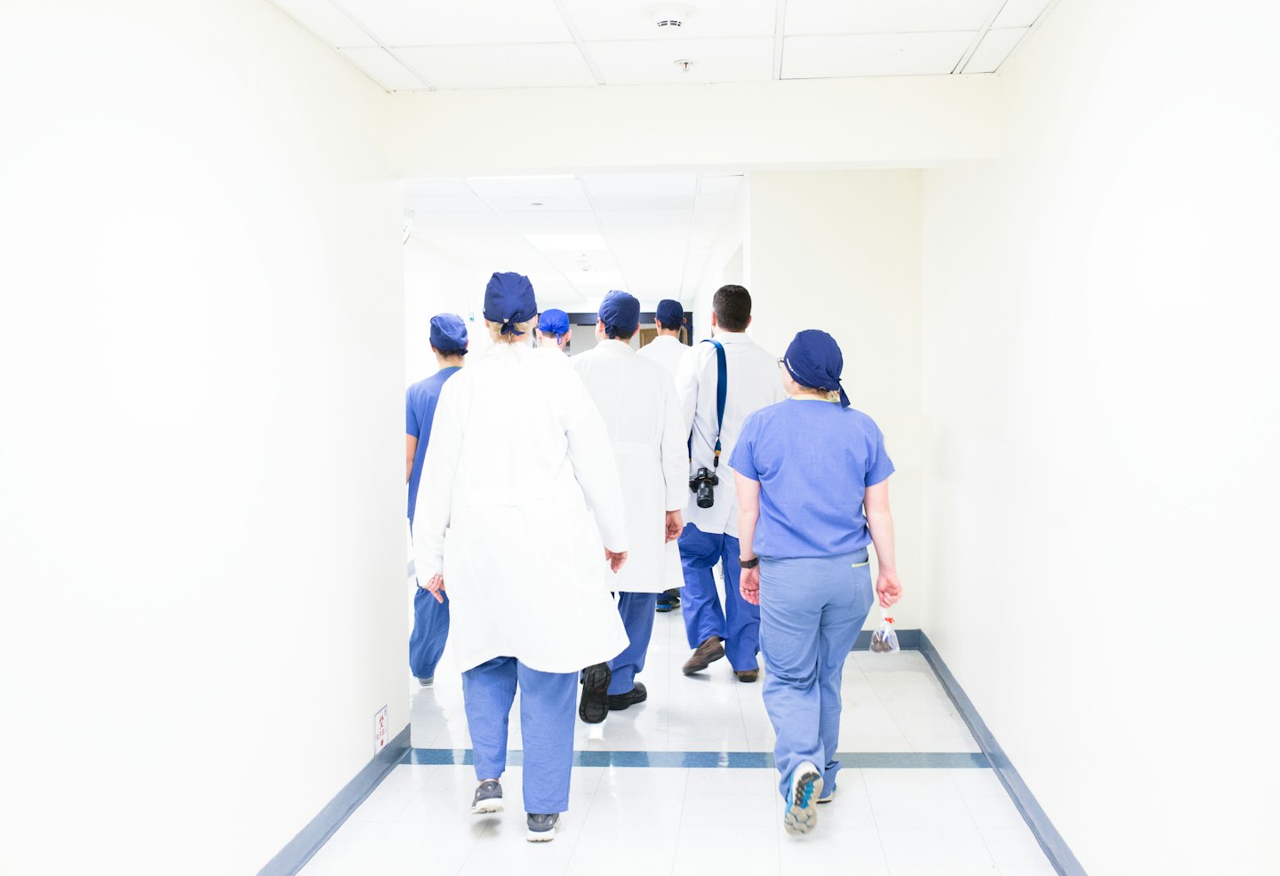 Medical professionals walking down a hospital hallway.